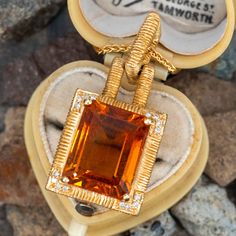 This fantastic pendant is centered with an emerald cut citrine, weighing 8.91 carats, in a four-prong setting. The corners are each bead set with four (4) round brilliant cut diamonds. The pendant measures 33.3mm long, including the bail, by 15.9mm wide by 11.4mm deep and hangs on an 18-inch long wheat link chain that is finished with a lobster claw clasp. Luxury Custom Yellow Gold Gemstone Necklace, Luxury Citrine Gemstone Jewelry, Timeless Citrine Gemstone Jewelry, Timeless Topaz Jewelry Gift, Elegant Yellow Emerald Cut Jewelry, Elegant Emerald Cut Yellow Jewelry, Luxury Amber Jewelry For Formal Occasions, Timeless Citrine Jewelry As Gift, Timeless Citrine Jewelry For Gift