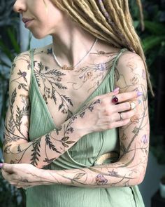 a woman with tattoos on her arms and chest