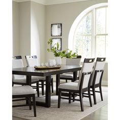 a dining room table and chairs in front of a large window with potted plants