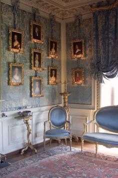 a room with pictures on the wall and blue chairs in front of it is shown