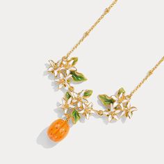 Embrace the essence of timeless elegance with our Golden Plum Blossom Pendant Necklace, a breathtaking embodiment of nature’s grace and refined artistry. This exquisite necklace is a masterpiece of design, where delicate blossoms and a radiant golden plum come together to create a piece that is both enchanting and sophisticated. The chain, a delicate gold tone, complements the pendant perfectly, ensuring that all eyes are drawn to the intricate details of the blossoms and the glowing plum. Indul Elegant Orange Pendant Necklaces, Golden Plum, Everyday Wear Jewelry, Astrology Jewelry, Astrology Necklace, Fruit Jewelry, Nature Earrings, Nature Necklace, Jewelry Lockets