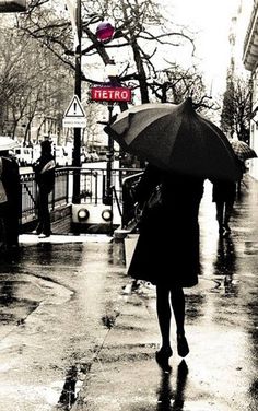 a woman walking down the street with an umbrella