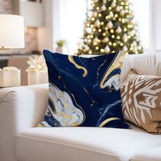 a living room with a christmas tree in the background and pillows on the couches