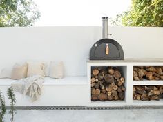 an outdoor fireplace with logs stacked on it