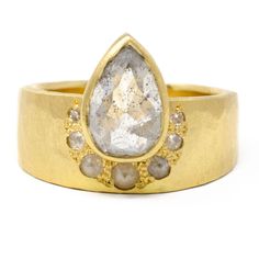 a yellow gold ring with a pear shaped diamond in the center and grey stones around it