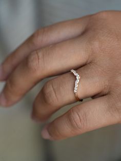 a woman's hand with a diamond ring on top of her left hand,