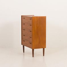 an old chest of drawers sitting on top of a white floor