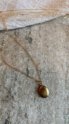 Mini brass locket on a gold fill chain. The daintiest oval shape, minimal + lovely. Can be stamped with one initial or birth flower on the inside, or filled with a picture. Dainty Gold Oval Locket Necklace, Gold Brass Dainty Locket Necklace, Gold Dainty Brass Locket Necklace, Dainty Brass Locket Charm Necklace, Dainty Gold Brass Locket Necklace, Dainty Gold Oval Pendant Locket Necklace, Gold Oval Pendant Brass Charm Necklace, Gold Oval Pendant Charm Necklace In Brass, Gold Brass Oval Pendant Charm Necklace