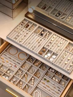 two drawers filled with jewelry on top of a table