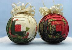 two christmas ornaments sitting on top of a snow covered ground next to each other with bows