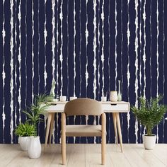 a chair and table in front of a blue wall with white paint streaks on it