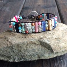 This multi color beaded bracelet for women is stunning and unique. This single wrap bracelet would compliment and outfit you want to wear it with. This bracelet would be a beautiful meaningful gift for your mother on Mother's Day. It will be a gift she can enjoy every day. This leather beaded bracelet is made with a variety of gemstone beads in various sizes and colors. Please choose the size you would like at check out. Adjustable Cuff Bracelet With Colorful Beads For Gifts, Adjustable Cuff Bracelet With Colorful Beads As Gift, Multicolor Beaded Wrap Bracelet As Gift, Multicolor Beaded Friendship Wrap Bracelet, Bohemian Cuff Bracelet With Hand Wrapped Round Beads, Artisan Beaded Multicolor Wrap Bracelet, Bohemian Hand Wrapped Cuff Bracelet With Round Beads, Artisan Multicolor Beaded Wrap Bracelet, Bohemian Hand-wrapped Round Bead Cuff Bracelet