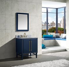 a bathroom with a blue cabinet, mirror and window seat in it's corner