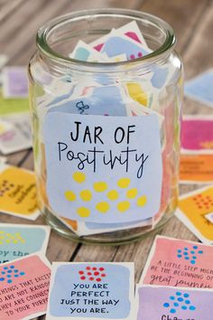 jar of post - it notes sitting on top of a table next to some cards