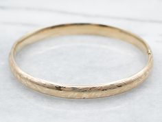 The details on this vintage 14-karat gold bangle are simply stunning! Intricate scrolling botanical designs are engraved in warm yellow gold, covering the entire bracelet. Beautiful on its own or layered with other bracelets this piece is perfect for day or evening wear.Metal: 14K Yellow GoldWidth: 6.3 mmInside Circumference: 6 1/2 InchesMarks: "JW 14K" Stamped on the inside band Antique Round 14k Gold Bangle, Antique 14k Gold Bangle Bracelet, Antique 14k Gold Round Bangle, Heirloom 14k Gold Round Bracelets, Heirloom 14k Gold Bracelets, Heirloom 14k Gold Round Bracelet, Heirloom 14k Gold Wedding Bracelet, Heirloom Wedding Bracelet Stamped 14k, Heirloom Style Engraved Bangle For Formal Occasions