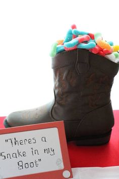 a pair of brown boots sitting on top of a table next to a sign that says, there's a joke in my boot too?