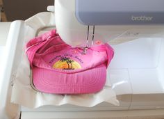 a pink hat sitting on top of a sewing machine