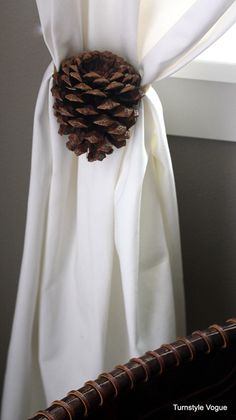 a white curtain with a pine cone on it