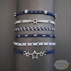 Welcome to Stormy Day Crafts, where style meets celestial charm! Introducing our Midnight Stars Stackable Friendship Bracelet Sets - crafted to add a touch of enchantment to your everyday moments. ⭐ Set of 6, Set of 3, and Individual Bracelets: Choose from our versatile options: Full set of all 6 bracelets, a set of 3 bracelets, or individual bracelets to suit your preferences. Mix and match for a ook that's uniquely yours. In Set A 1: Dark Blue with Silver Beads 2: Light Grey with Blue Beads 3: Dark Blue Beaded Bracelet, Blue Friendship Bracelet Patterns, Trio Friendship Bracelets, Friendship Bead Bracelets, Star Friendship Bracelet, Trio Bracelets, Dark Blue Bracelet, Blue Friendship Bracelet, Space Bracelet