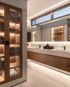 a large bathroom with two sinks and wooden cabinets