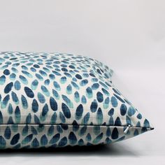 a blue and white pillow sitting on top of a table