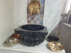 a bathroom with marble counter tops and gold accents on the wall, along with bowls