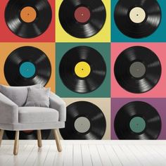 vinyl record wallpaper in a living room with a grey chair and multicolored background