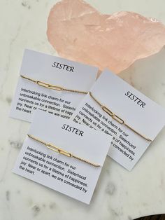 three sister bracelets on top of a table next to a pink quartz crystal rock