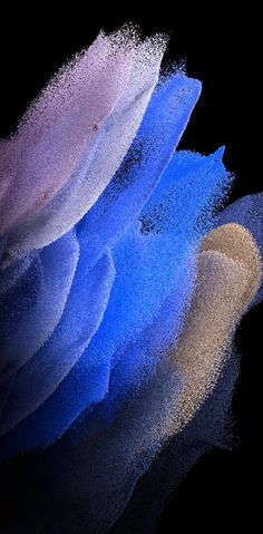 three different colored powdered objects on a black background