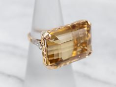 What a beauty! The centerpiece of this lushly shaded ring is the bright, golden-hued citrine that we've set at the center. Although filled with neutral tones that will go with anything, this amazing mounting is filled with color and light sparkling from the twinkling diamonds!Metal: 18K Yellow and White GoldGem: Citrine 27.20 Carats Gem Measurements: 21.7 x 15.8 mm, Emerald CutAccents: 6 Diamonds totaling .08 Carats, SI-I in Clarity, G-I in ColorRing Size: 5.75 Color And Light, Diamond Cocktail Ring, Filigree Pendant, Diamond Cocktail Rings, Rose Gold Band, White Gold Band, Diamond Drops, Vintage Turquoise, Diamond Drop Earrings