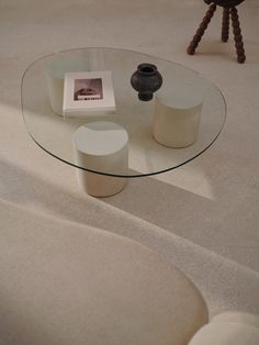 a glass table sitting on top of a white carpeted floor next to a chair