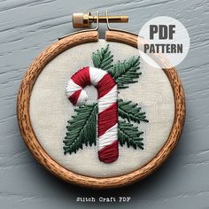 a cross stitch christmas ornament with a candy cane in the shape of a t