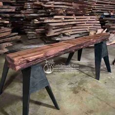 a wooden bench sitting in front of stacks of wood planks and metal legs on the floor