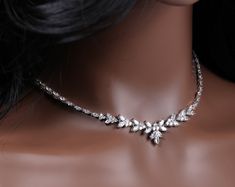 a woman's head wearing a necklace with leaves on the front and back of it