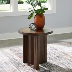 a round table with a plant on top and a pair of glasses sitting on it