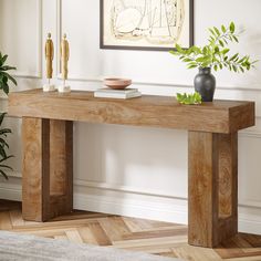 a wooden table with two vases on it and a plant in the corner next to it