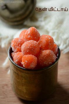 small bowl filled with sugar covered donuts on top of a wooden table