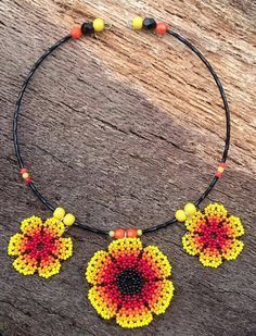 My flower choker is definitely for a Boho girl or lady, who has a love for bright and sunny colours and nature. What better way to add some sunshine to your life than with this lightweight piece?  Repurposed beaded flowers.  Repurposed wooden yellow beads. Repurposed black and orange plastic crystals. Repurposed small plastic orange and yellow beads. Repurposed black glass seed beads. New silver plated memory wire. New silver plated jump rings. Approximately 15.5cm long. Central flower approxima Handmade Round Beads Choker For Festivals, Handmade Choker With Round Beads For Festivals, Hippie Beaded Choker Necklace As Gift, Adjustable Hippie Flower Jewelry, Handmade Red Flower Necklace Adjustable, Handmade Adjustable Red Flower Necklace, Multicolor Bohemian Flower Necklace With Tiny Beads, Bohemian Choker With Tiny Beads For Gift, Handmade Red Flower Necklace With Adjustable Fit