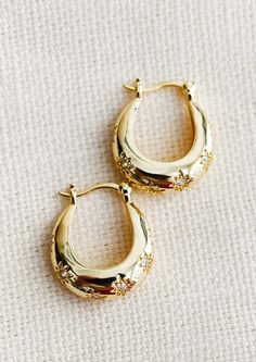 A pair of oblong oval hoops in gold with clear star shaped crystal detailing. Gold Mini Hoop Earrings, Classy Gold Earrings, Earthy Gold Jewelry, Gold Earring Stack, Gold Chunky Earrings, Chunky Gold Earrings, Little Hoop Earrings, Gold Hoops Earrings, Thick Gold Hoop Earrings