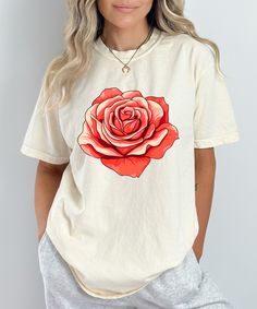 Add a touch of elegance to your wardrobe with this stunning floral design shirt featuring a vibrant red rose. Perfect for those who love nature-inspired fashion, this flower graphic tee is both stylish and versatile, making it a great choice for casual outings or dressing up with accessories. Crafted from high-quality, soft fabric, this botanical print t-shirt ensures comfort and durability. The bold rose design stands out beautifully against the black background, making it a statement piece that's sure to draw compliments. Whether you're a plant lover, a fan of floral patterns, or simply looking for a unique gift for her, this floral t-shirt for women is a perfect addition to any wardrobe. Key Features: Premium Quality: Made from soft, breathable fabric for all-day comfort. Vibrant Design Summer Short Sleeve T-shirt With Rose Print, Summer Rose Print Short Sleeve T-shirt, Summer Graphic Tee With Rose Print, Spring Rose Print Short Sleeve T-shirt, Spring Cotton T-shirt With Rose Print, Rose Print Tops For Spring, Casual Rose Print Crew Neck T-shirt, Spring Graphic Tee With Rose Print, Spring Rose Print Graphic Tee