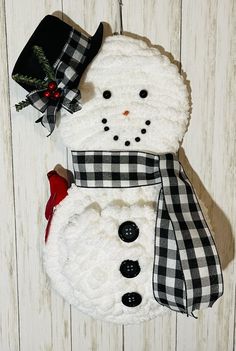 a white snowman with black and white checkered scarf