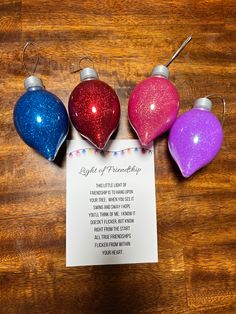 three christmas ornaments and a note on a wooden table with a poem written in it