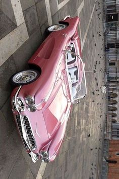 a pink car parked on the side of a road