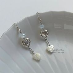 "Handmade Beaded Earrings ✿ Made with glass beads, freshwater pearls, glass crystal beads, and metal accents ✿ Silver, clear milky white, and pearlescent off white ✿ The earrings are 2.9\" long Fish Hook Options ✿ The Titanium fish hook is hypoallergenic and ideal for sensitive skin ✿ The regular fish hook is made of nickel free metal, it is not hypoallergenic" White Dangle Crystal Earrings With Pearl Drop, White Pearl Crystal Earrings For Pierced Ears, White Pearl Crystal Earrings, White Heart Beads Drop Earrings, White Drop Earrings With Heart Beads, White Metal Dangle Beaded Earrings, White Beaded Metal Earrings, White Pearl Charm Earrings In Metal, Nickel-free White Crystal Metal Earrings