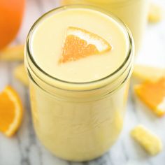 two glasses filled with orange juice on top of a table