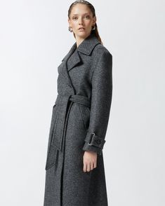 Women's long double-breasted coat made from yarn-dyed wool-blend twill cloth. The silhouette—which includes a lapel collar, long sleeves with cuff tab and matching-fabric waist belt—is inspired by the classic trench coat. Slanted side pockets and double-breasted button fastening. Luxury Wool Coat With Belted Cuffs For Office, Formal Wool Coat With Belted Cuffs And Notch Lapel, Formal Wool Coat With Belted Cuffs And Lapel Collar, Formal Double-breasted Wool Coat With Belted Cuffs, Formal Long Wool Coat With Belted Cuffs, Classic Wool Coat With Notch Lapel And Belted Cuffs, Office Wool Coat With Notch Lapel And Belted Cuffs, Classic Wool Coat With Belted Cuffs For Office, Chic Wool Coat With Belted Cuffs And Notch Lapel