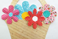 a wooden basket with paper flowers on it