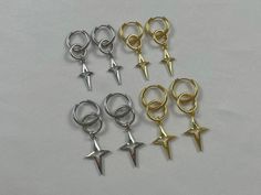 Lovely silver or gold huggies with dangling Polaris stars These earrings are the perfect minimalistic, celestial, and everyday pair for anyone! Wear them with any kind of style, vibe, or personality! They come in silver or gold, and two different sizes! *LENGTH- 4.7/5.7cm *DROP LENGTH- 3.2/4cm *EARRING WIDTH- 14/16mm ♡ All earring clasps in my store are hypoallergenic / nickel free ♡ All parts of these earrings are nickel free ♡ All the jewelry in my store is handmade by me! ♡ For longer wear please avoid moisture ♡ Packaged with love and care! ♡ Canadian based Keeping the jewelry in quality care is a priority for Dauntelia. Every piece is handmade as delicately as possible and packaged with absolute love, care, and thought. You never know when or if oxidation may occur and tarnish certain Trendy Metal Hoop Earrings With Star Charm, Tarnish Resistant Metal Dangle Cartilage Earrings, Trendy Silver Huggie Piercings, Trendy Nickel-free Dangle Piercings, Trendy Dangle Metal Piercings, Trendy Metal Dangle Piercings, Y2k Silver Star Jewelry, Y2k Style Silver Star Jewelry, Earrings Grunge