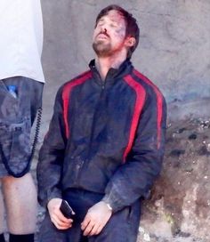 a man sitting on the ground with his eyes closed