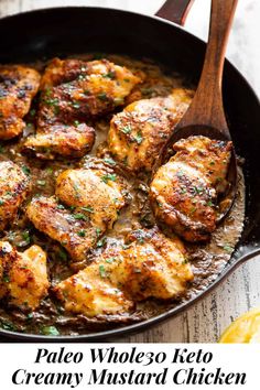 chicken thighs in a skillet with lemon wedges and parsley on the side